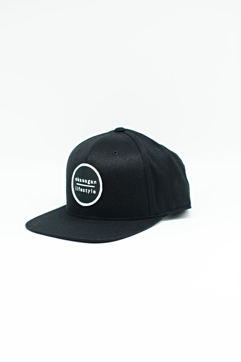 The Classic Okanagan Lifestyle wordmark logo embroidered white on our favorite black snapback